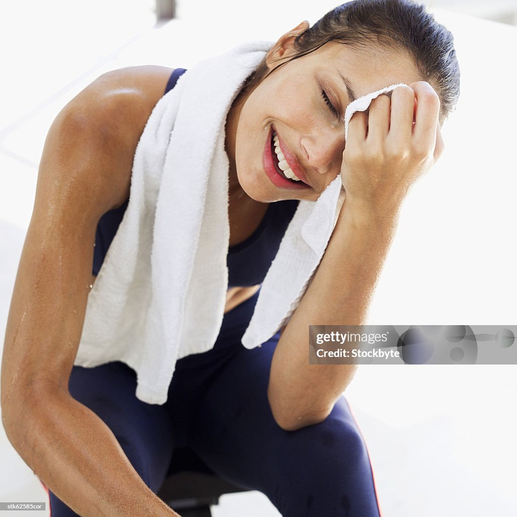 Close-up of a woman wiping her face with a towel