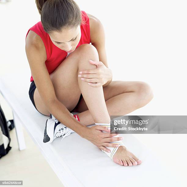 elevated view of a woman holding her injured ankle - injured hand stock pictures, royalty-free photos & images
