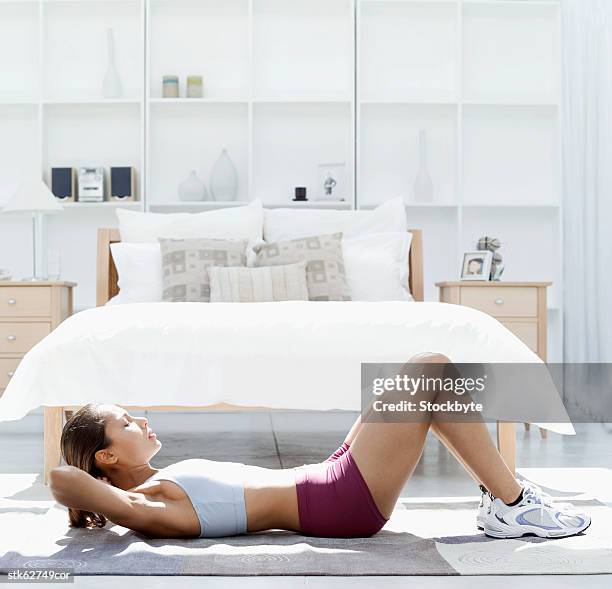 side view of a woman doing sit ups on the floor - duing stock pictures, royalty-free photos & images
