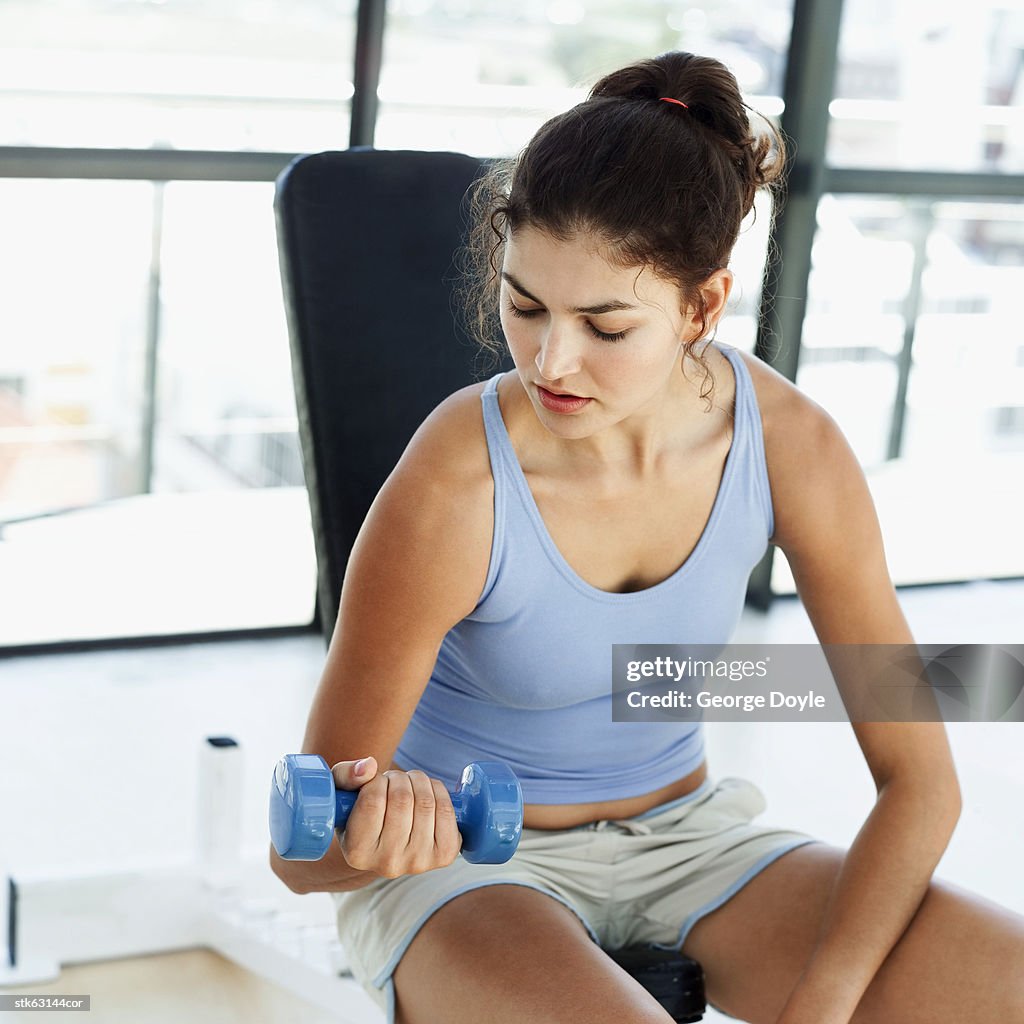 Woman exercising using a dumbbell