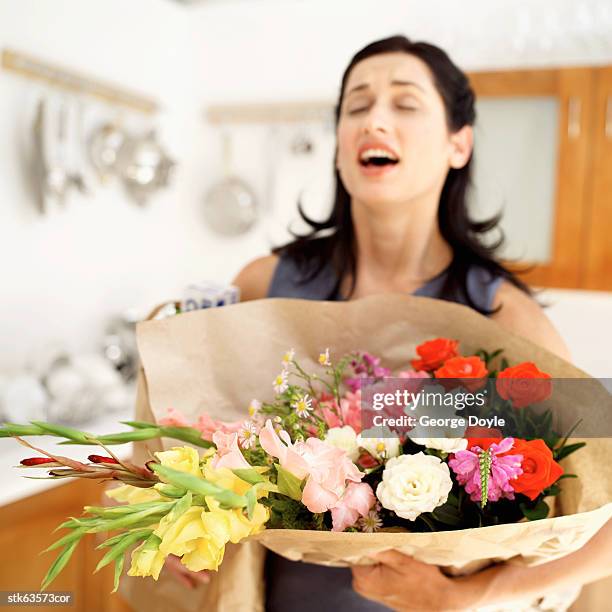 woman carrying a bouquet of flowers - temperate flower stockfoto's en -beelden