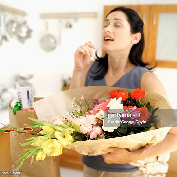 woman sneezing while holding a bouquet of flowers - lily family stock pictures, royalty-free photos & images