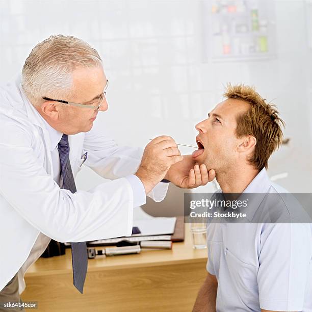 portrait of an elderly male doctor examining a patient - screening of abramoramas hare krishna the mantra the movement and the swami who started it all arrivals stockfoto's en -beelden