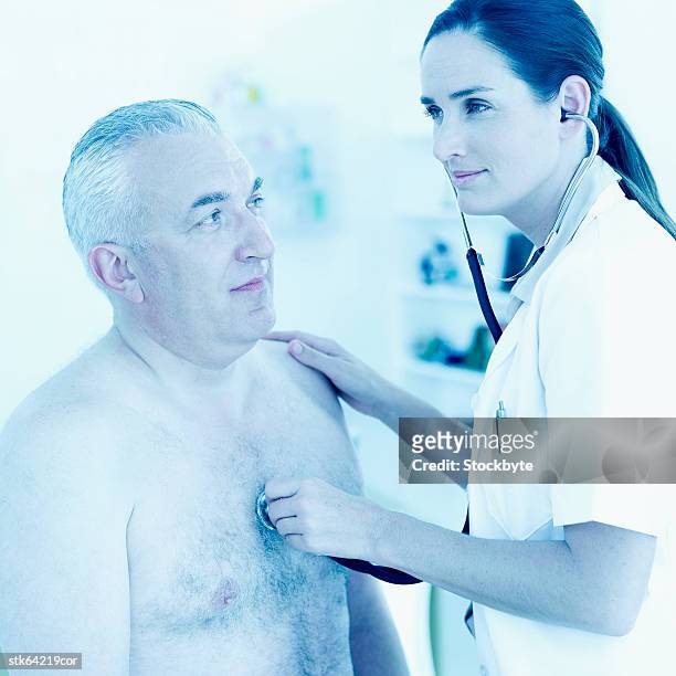 nurse checking heart beat of elderly man with a stethoscope - female hairy chest photos et images de collection