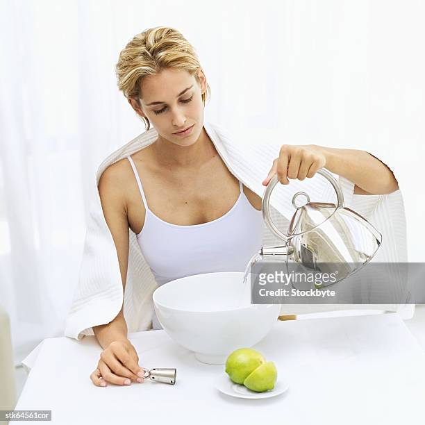 woman pouring water from a kettle into a basin - basin ストックフォトと画像