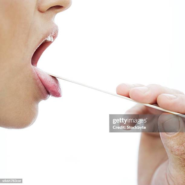 woman's throat checked with a tongue depressor - screening of la legende de la palme dor after party at china tang stockfoto's en -beelden