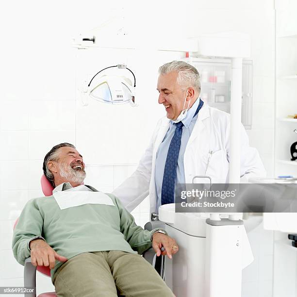 an elderly male dentist laughing with his male patient - screening of abramoramas hare krishna the mantra the movement and the swami who started it all arrivals stockfoto's en -beelden
