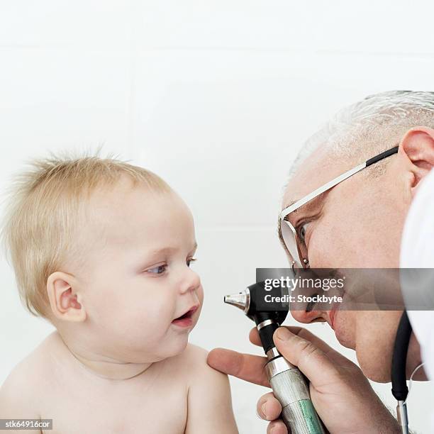 close-up of a doctor examining a baby (6-12 months) with an ophthalmoscope - screening of abramoramas hare krishna the mantra the movement and the swami who started it all arrivals stockfoto's en -beelden