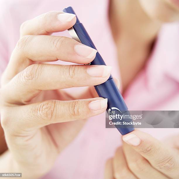 close-up of a woman removing blood from her finger for a blood test - screening of la legende de la palme dor after party at china tang stockfoto's en -beelden