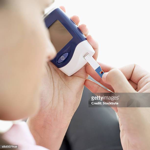 a person using a hand held blood sugar tester - screening of abramoramas hare krishna the mantra the movement and the swami who started it all arrivals stockfoto's en -beelden