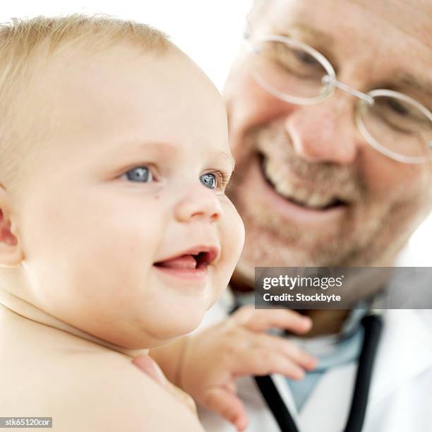 close-up of a healthy baby being checked by a doctor - unknown gender 個照片及圖片檔