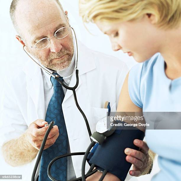 doctor checking the blood pressure of woman - screening of abramoramas hare krishna the mantra the movement and the swami who started it all arrivals stockfoto's en -beelden