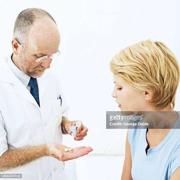 male doctor showing tablets to a female patient - screening of abramoramas hare krishna the mantra the movement and the swami who started it all arrivals stockfoto's en -beelden