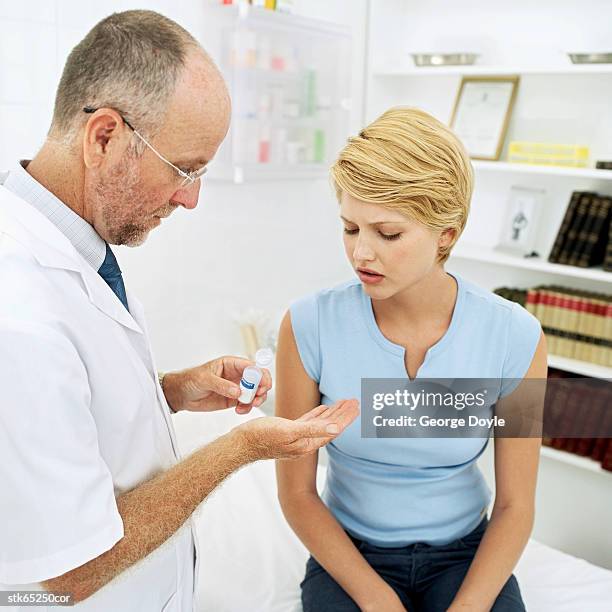 doctor giving pills to woman - screening of la legende de la palme dor after party at china tang stockfoto's en -beelden