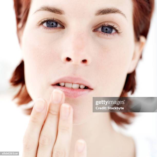 portrait of a woman touching her lip - painful lips stock pictures, royalty-free photos & images