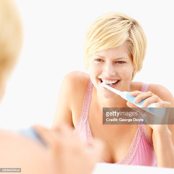 woman using an electric toothbrush - inside the link real estate investment trust properties ahead of interim results stockfoto's en -beelden