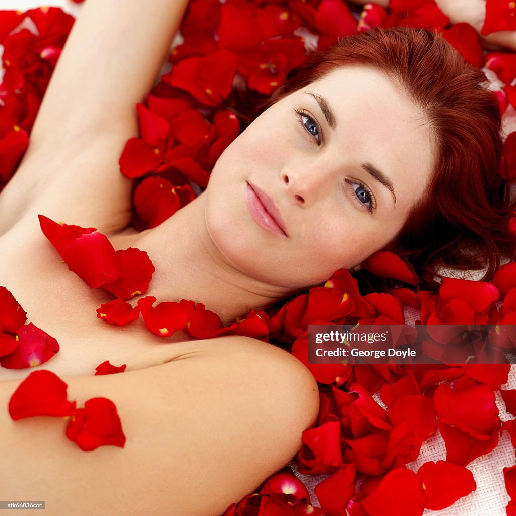 Close-up of a woman covered in rose petals
