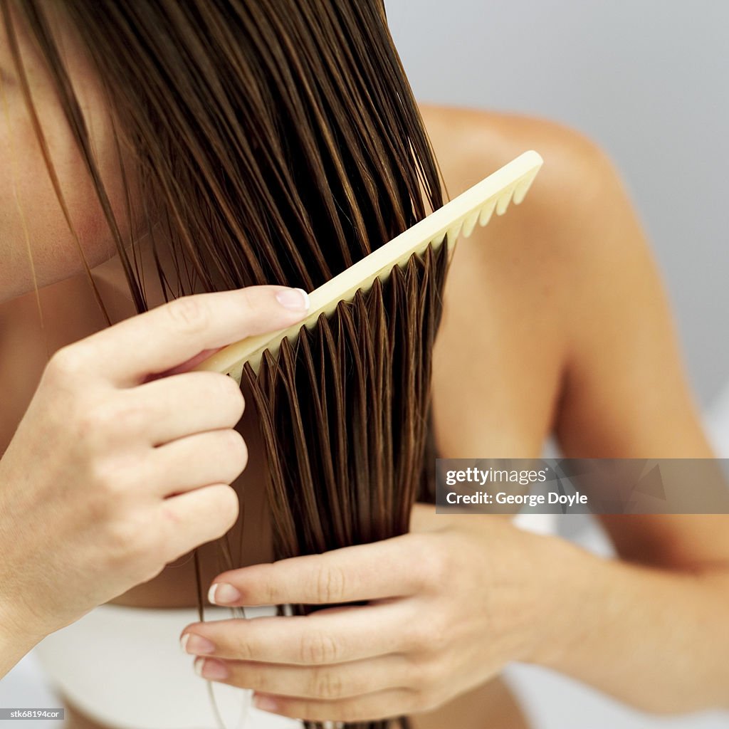 Close-up of a woman combing her wet hair