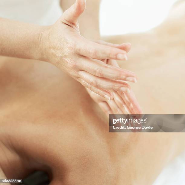 close-up of a woman massaging a man's back - dorso umano foto e immagini stock