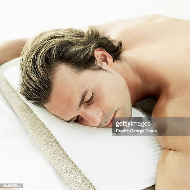 high angle view of a young man sleeping on his stomach - dorso umano foto e immagini stock