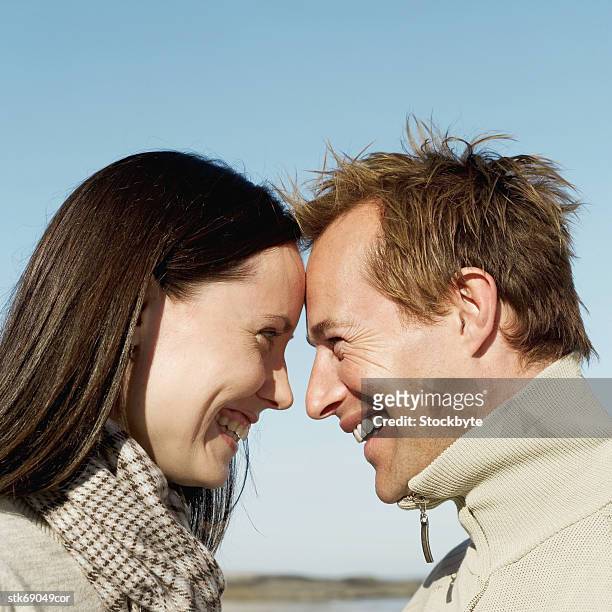 side profile of a smiling couple looking into each other's eyes - other stock-fotos und bilder