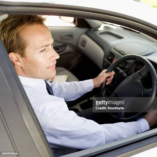 side profile of a businessman in the driver's seat of a car - in profile stock pictures, royalty-free photos & images