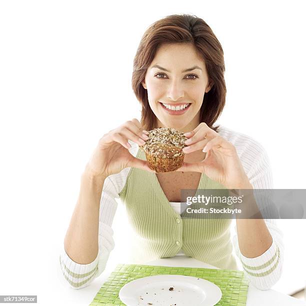 portrait of a young woman holding a muffin - muffin top stock-fotos und bilder