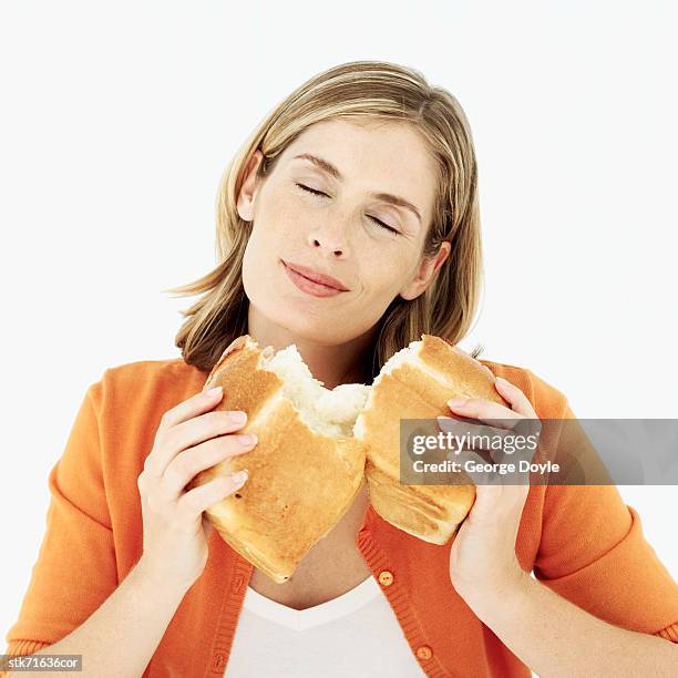 woman smelling a loaf of broken bread - george nader stockfoto's en -beelden