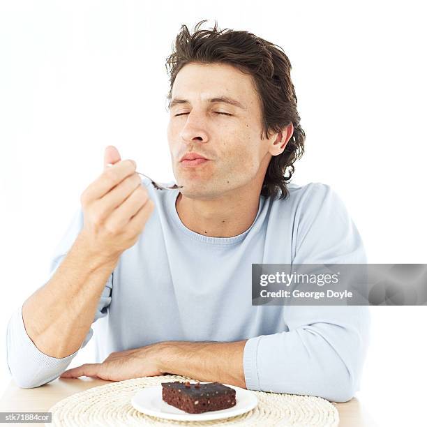 portrait of a man savoring a brownie with his eyes closed - cake top view stock pictures, royalty-free photos & images