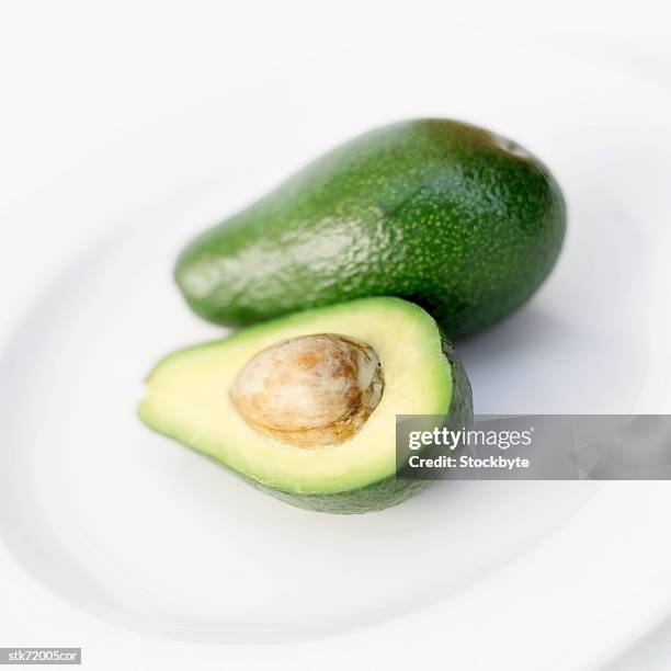 close-up of an avocado on a plate - plant stage stock pictures, royalty-free photos & images