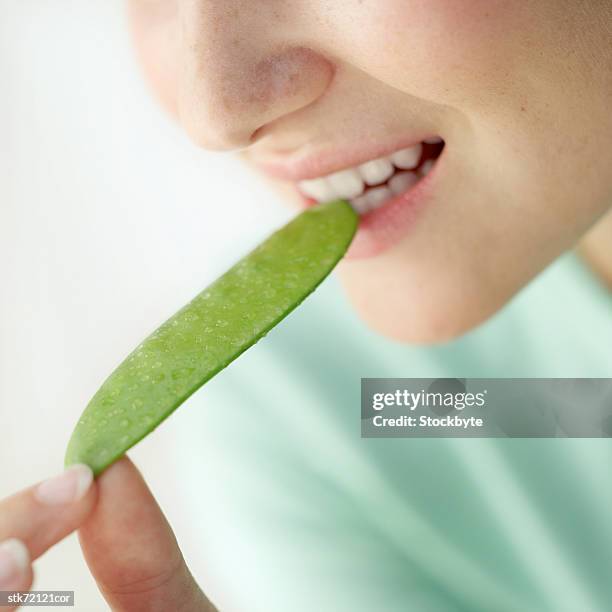 woman biting into a green bean - magnoliopsida 個照片及圖片檔