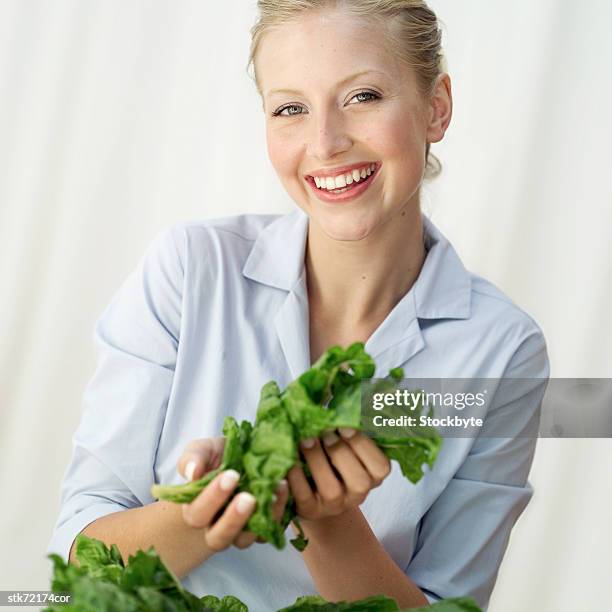 portrait of a woman holding washed greens in her hands - kreuzblütengewächse stock-fotos und bilder