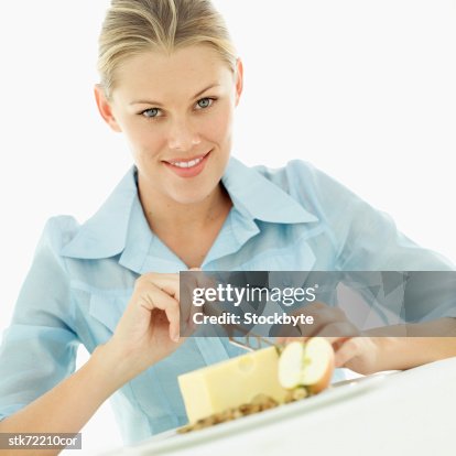 Portrait of a woman slicing cheese with a knife Portrait of a woman slicing cheese with a knife