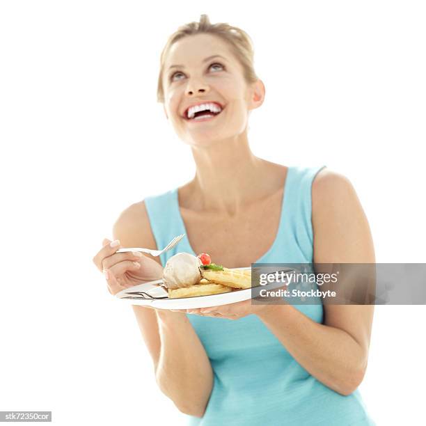 portrait of a woman holding a plate of dessert and looking up - gefrorene süßspeise stock-fotos und bilder