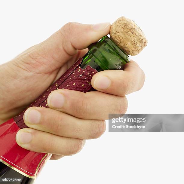 close-up of a man's hand opening the cork of a champagne bottle - opening celebration of gregory colberts ashes and snow exhibition arrivals stockfoto's en -beelden