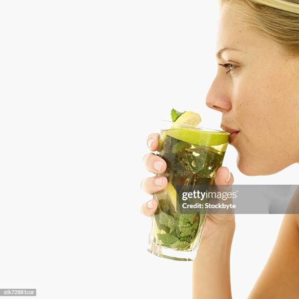 woman drinking a glass of lemon juice with mint leaves - lemon mint stock pictures, royalty-free photos & images