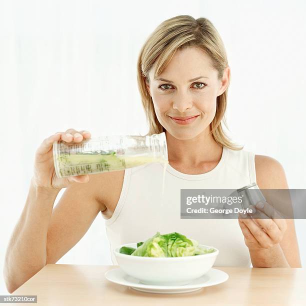 portrait of a woman pouring olive-oil over lettuce in a bowl - taste of john paul ataker presentation spring 2016 new york fashion week stockfoto's en -beelden