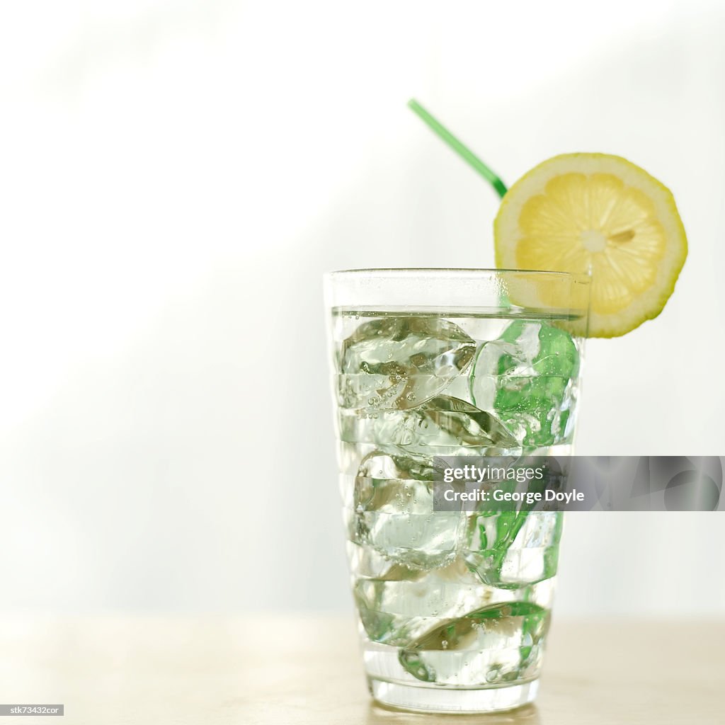 Close-up of a glass of water filled with ice and garnished with a lemon wedge