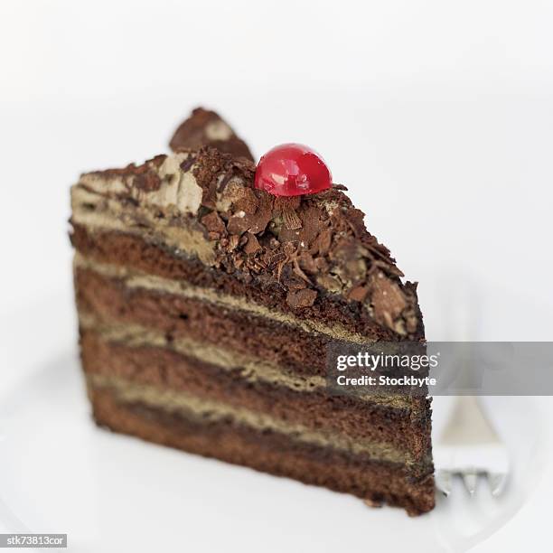 close-up of a slice of chocolate pastry with a cherry garnish - slice stock pictures, royalty-free photos & images