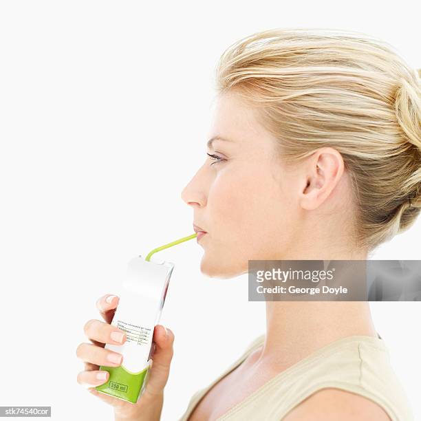 side profile of a woman drinking juice with a straw - juice carton 個照片及圖片檔