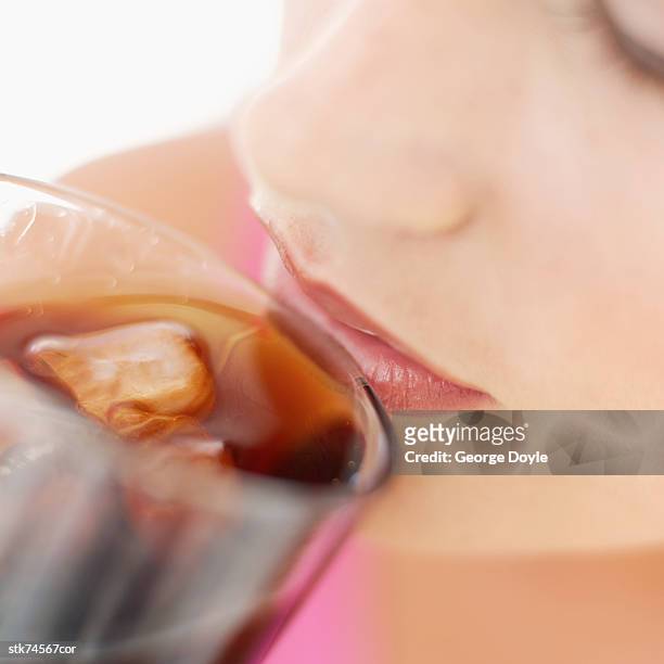 close-up of a woman drinking cola from a glass - künstliches eis stock-fotos und bilder