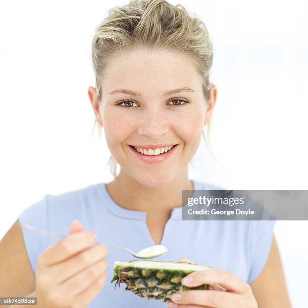 woman holding a spoon of dessert from a pineapple shell - gefrorene süßspeise stock-fotos und bilder