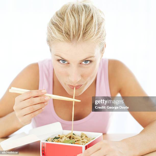 woman eating noodles from a take-out box with chopsticks - gen z studio brats premiere of chicken girls arrivals stockfoto's en -beelden