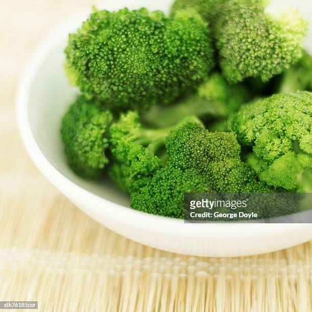 close-up of a bowl of cut pieces of broccoli - crucifers stock pictures, royalty-free photos & images