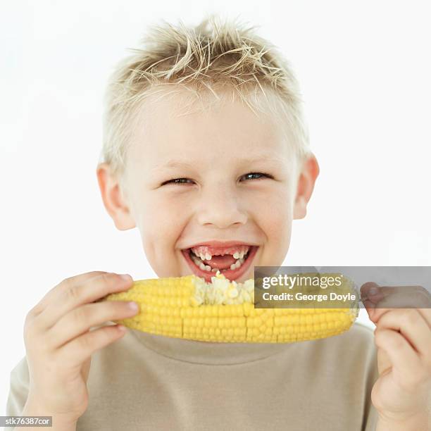 portrait of a boy (7-8) holding a corn on the cob - corn cob stock pictures, royalty-free photos & images