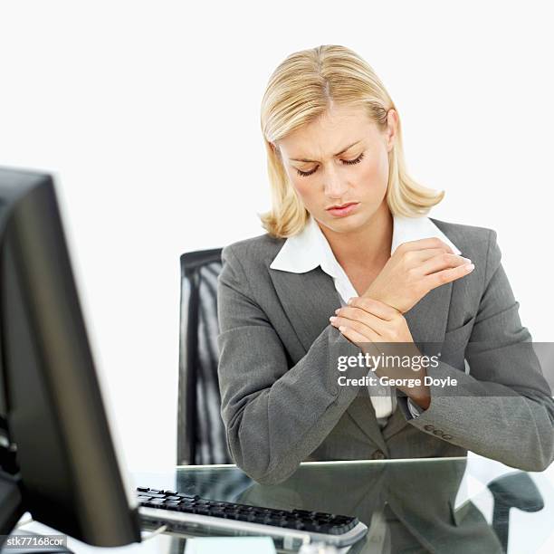 business woman sitting holding her wrist - menschliches gelenk stock-fotos und bilder