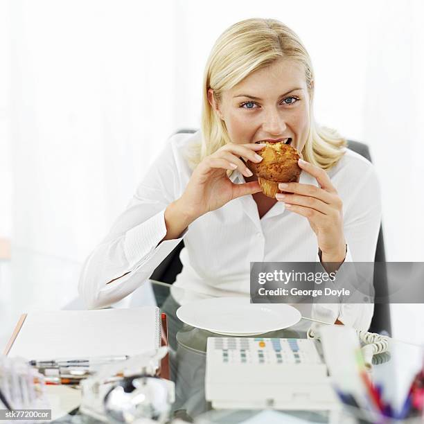 portrait of a young woman eating a muffin at her desk - ally hilfiger and adwoa aboah co host the launch of bite me at mama shelter hollywood stockfoto's en -beelden