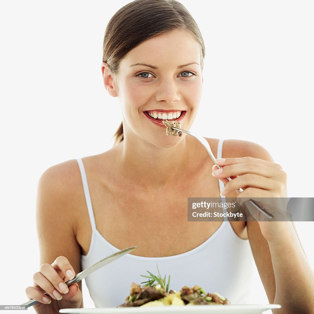 Portrait of a woman eating salad with a fork