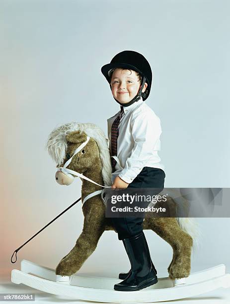 side profile of a boy (6-8) riding a rocking horse - in profile stock pictures, royalty-free photos & images