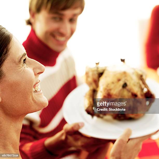 high angle view of a woman passing a roasted chicken around the table - gen z studio brats premiere of chicken girls arrivals stockfoto's en -beelden